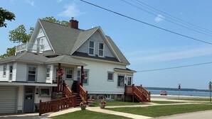 A two-story house with a front porch, a garage, and a view of the water.