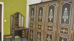 A room with a green wall, a wooden cabinet with intricate designs, a mirror, and a small stool. - Accommodation decorated with Moroccan craftsmanship (Rabat)