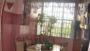 A dining area with a round table, chairs, and a decorative iron railing. - Accommodation decorated with Moroccan craftsmanship (Rabat)