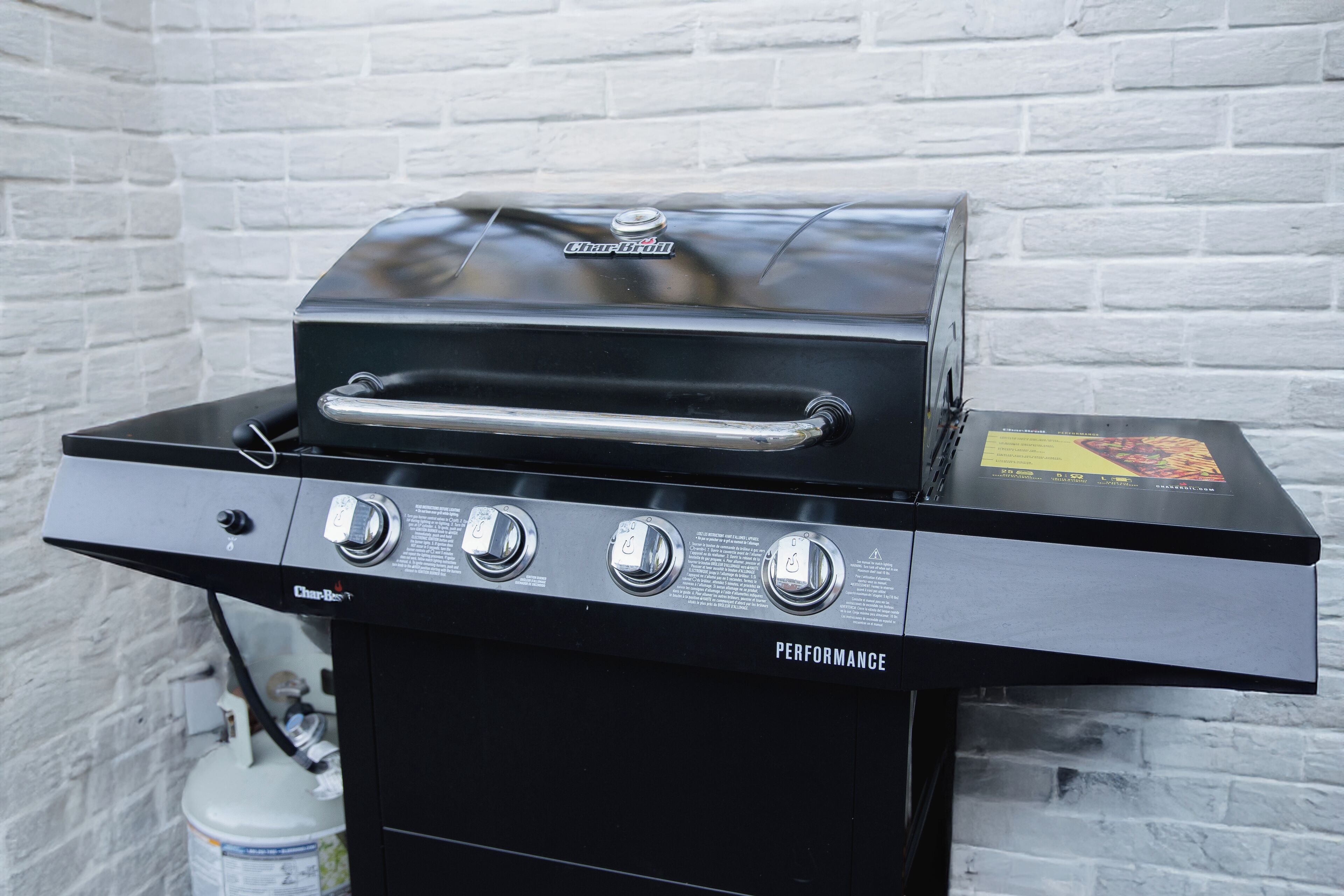 Ein schwarzer Char-Broil Performance Grill mit vier Reglern und einem Edelstahlgriff.