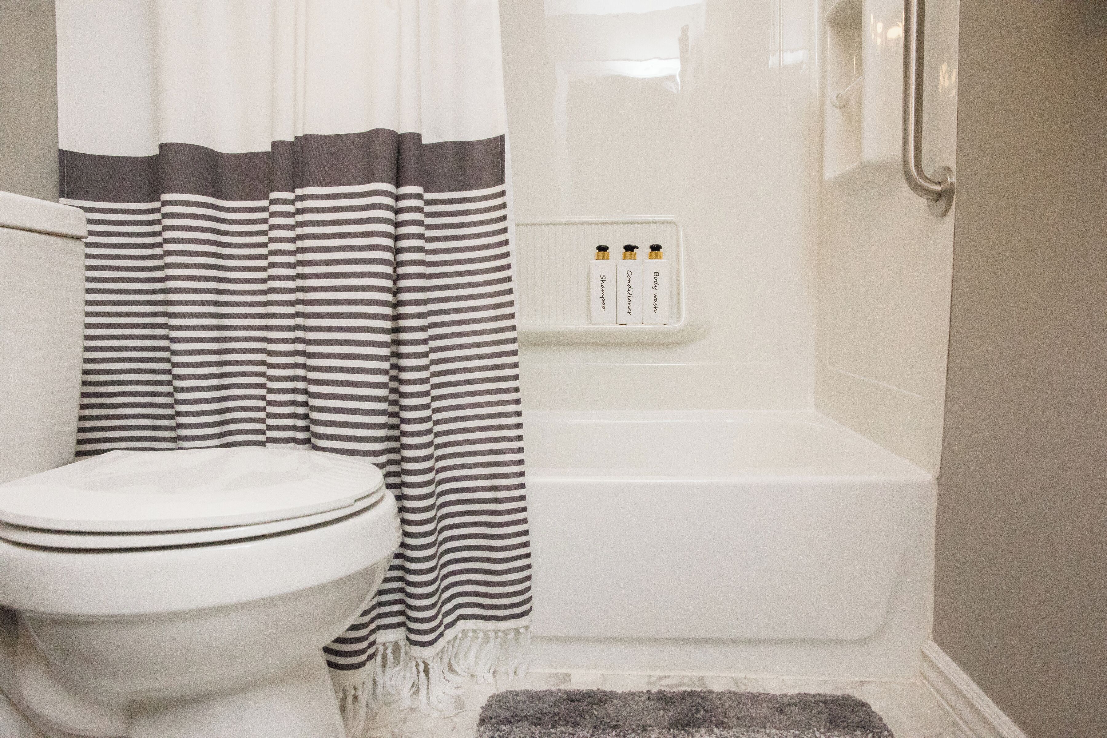 Une salle de bain équipée de toilettes, d’une baignoire et d’un rideau de douche.