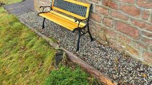 A stone building with a window and a bench outside. - Luichart Lodge (Garve)