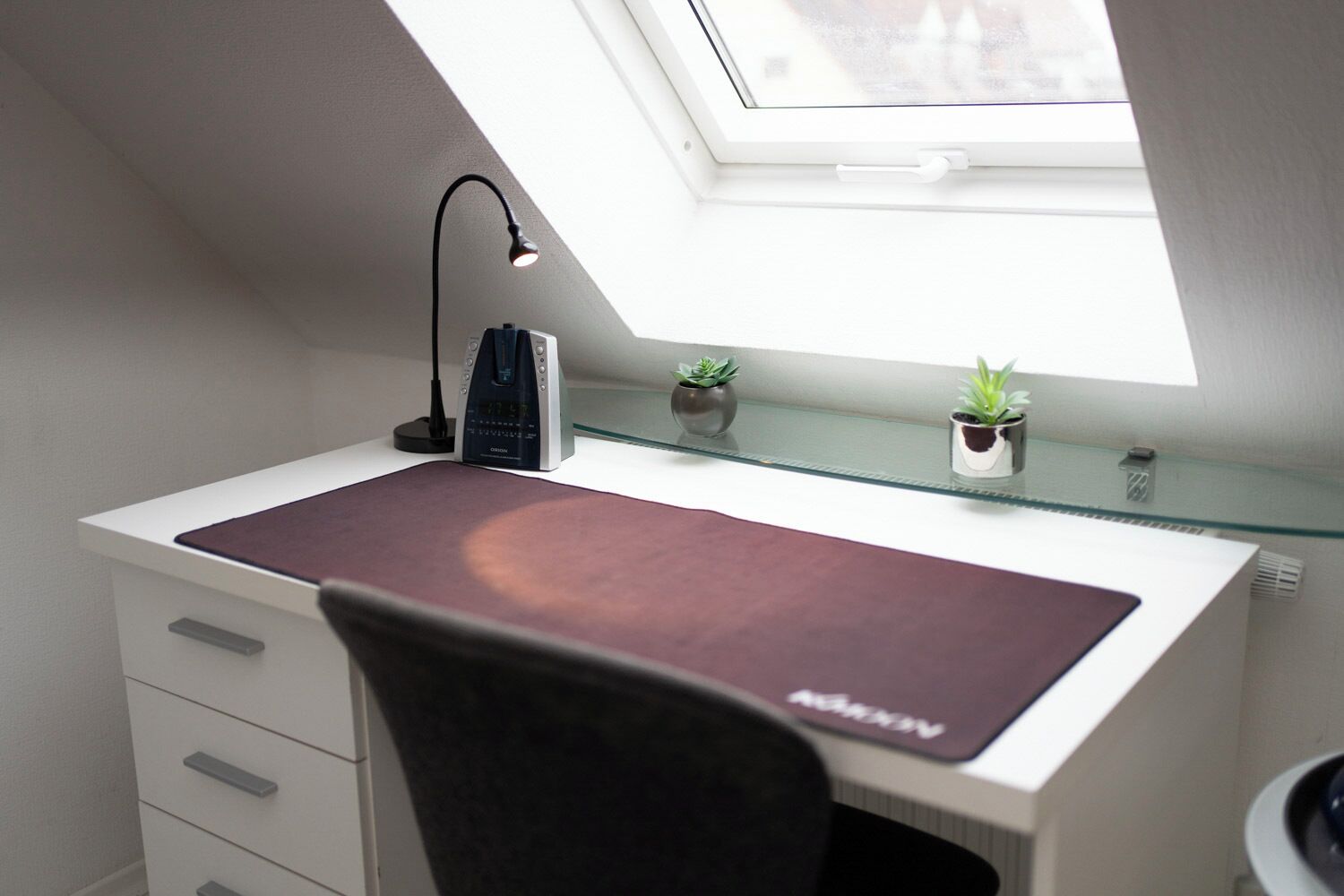 A study with a desk, chair, and a skylight.
