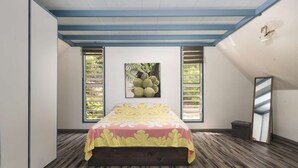 Ein Schlafzimmer mit einem Bett, zwei Fenstern mit Fensterläden, einer Decke mit blauen Balken und einem an der Wand hängenden Bild.