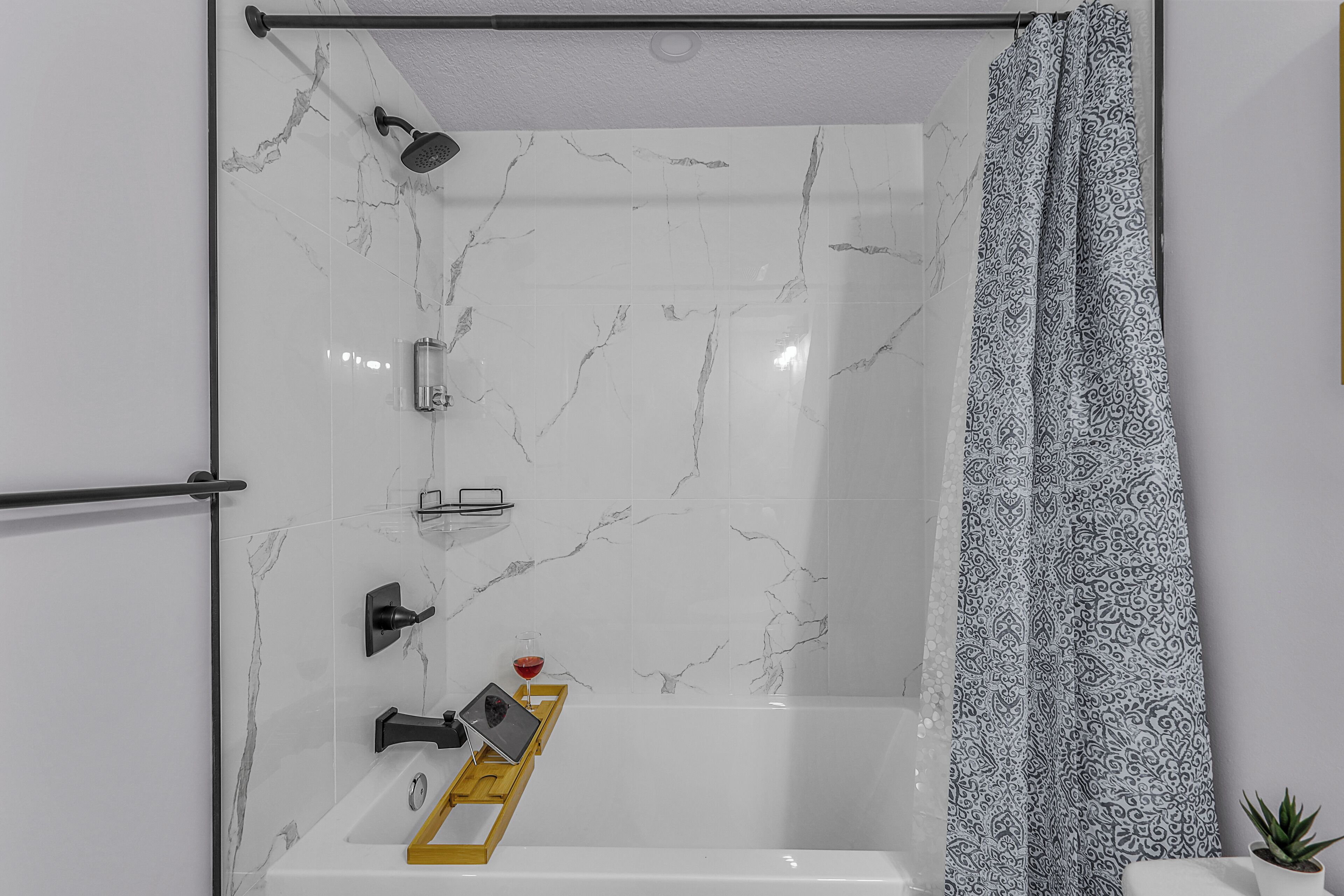 A modern bathroom with a shower, a bathtub, and a toilet.