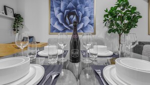 A dining table set with white plates, glasses, and a bottle of Belair Rose wine. - Luxury : Cozy| Modern| Clean| Spacious| easy Access to major routes in Calgary (Calgary)