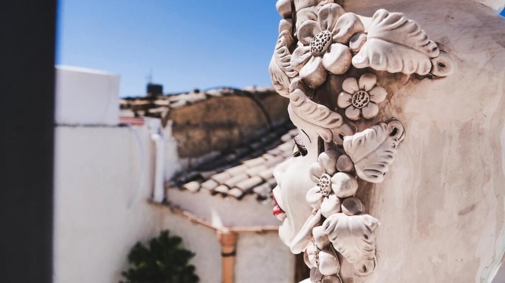 A close-up of a building's exterior with detailed floral carvings and a tiled roof.