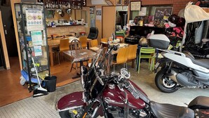 A motorcycle repair shop with a dining area, a bar, and various motorcycle parts and tools. - Near Ikebukuro area Divers & Bikers room (板橋区)