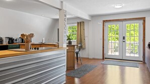 Een moderne keuken met een houten aanrecht, roestvrijstalen apparatuur en een grijze spatwand.
