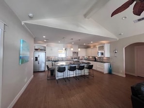 A spacious kitchen with a central island, bar stools, and modern appliances.