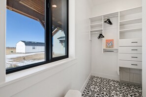 A room with a large window, white shelving, and patterned floor tiles. - Daydream Entire Home with Teton Views and Private Hot Tub (Tetonia)