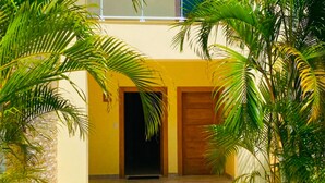 Un bâtiment à deux étages, doté d’une façade jaune, d’une entrée abritée et d’un chemin menant à l’entrée.