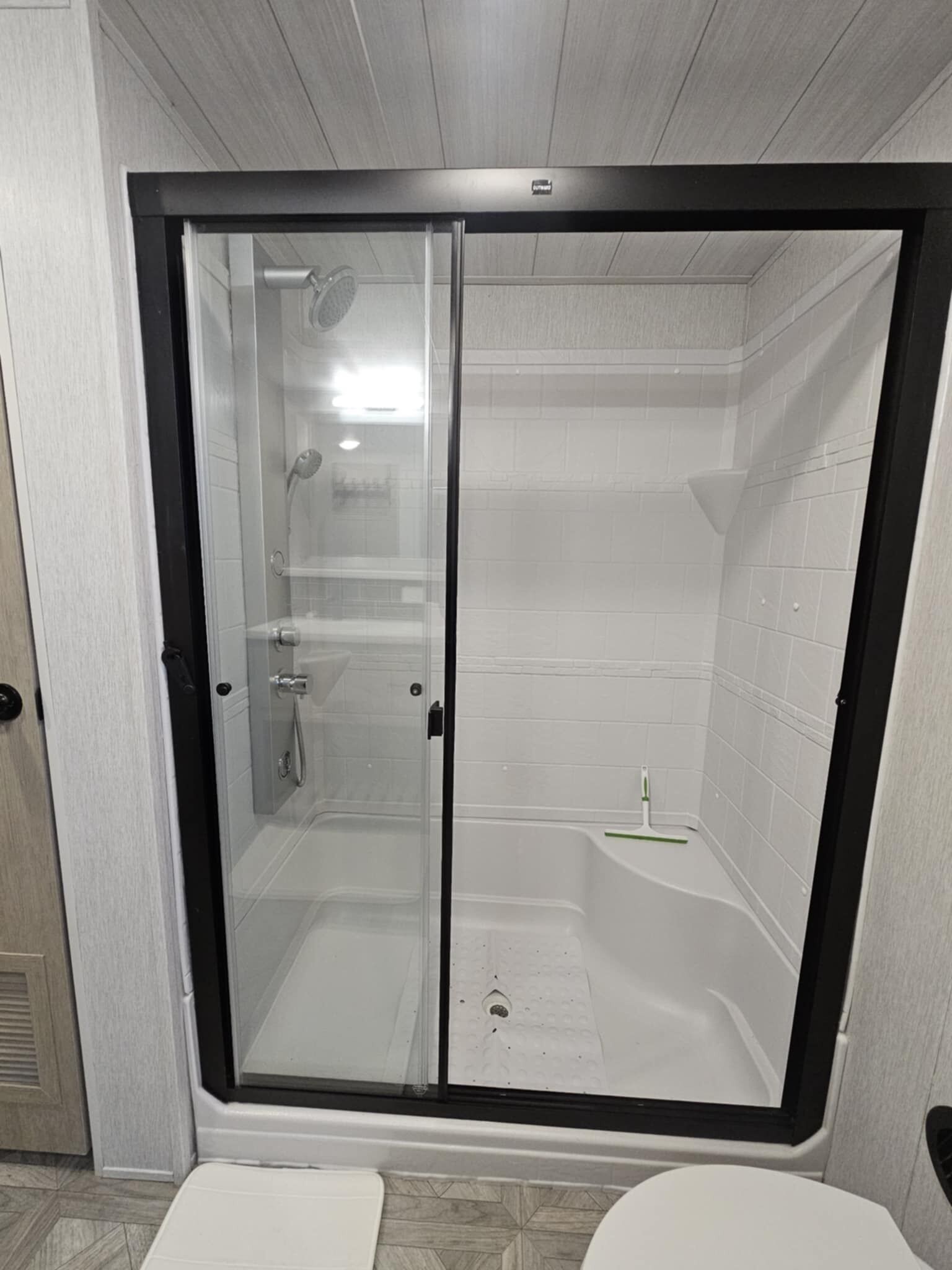 A modern bathroom with a glass-enclosed shower stall, a separate toilet, and a bathtub.