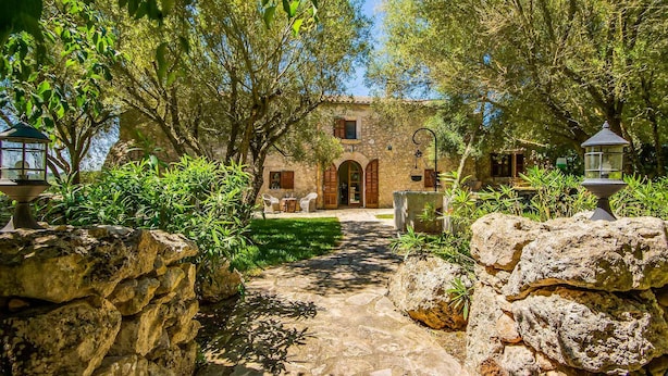 A stone pathway leading to a rustic stone building with a garden and lanterns. - Cozy home in Llubi with private swimming pool, can be inside or outside (Llubi)
