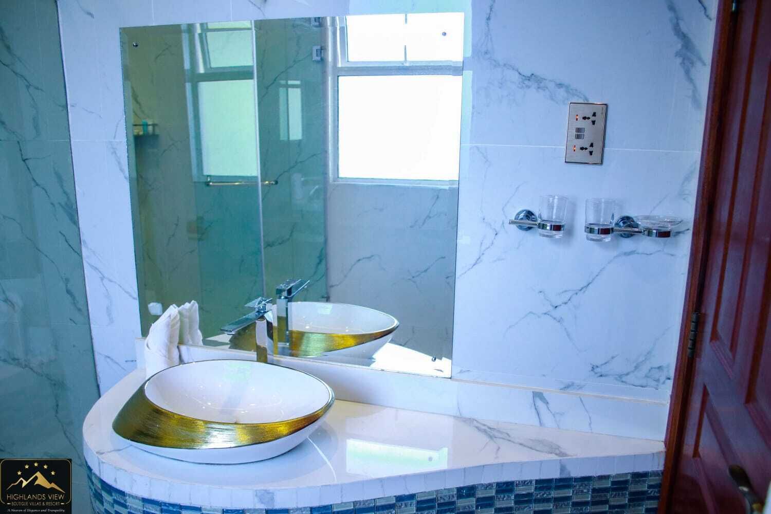 Un baño con un espejo grande, dos lavamanos y una pared de mármol.