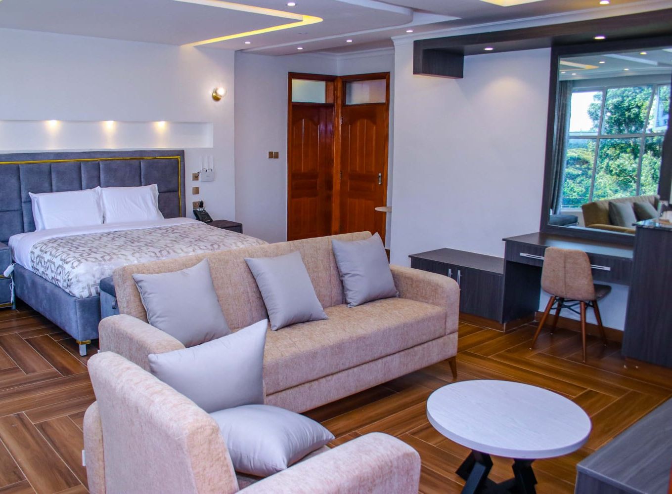 Une chambre moderne avec un grand lit, un canapé, un bureau et une chaise.