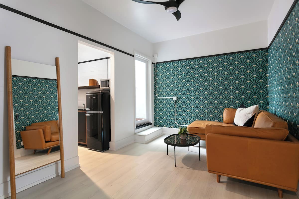 A modern living room with a sofa, coffee table, and a decorative mirror.