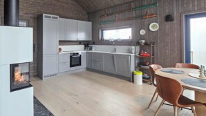 A modern kitchen with grey cabinets, a built-in oven, and a window above the sink.