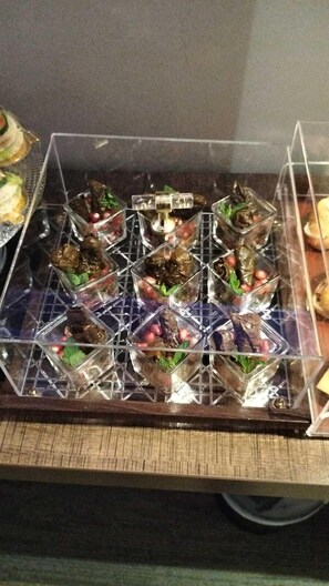 A display case containing various food items, likely for a buffet or catering service. - hotel alfal alshemaly (Duba)