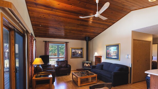 Una sala de estar acogedora con chimenea, techo de madera y un sofá.
