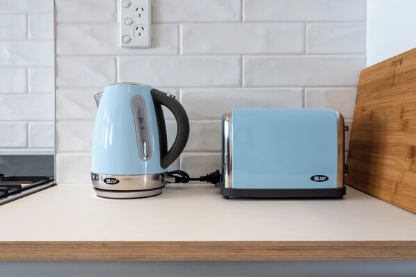 A kitchen counter with a kettle and a toaster.