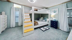 A bunk bed room with a staircase, a dresser, a nightstand, and a window with curtains.
