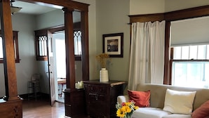 Ein Wohnzimmer mit rundem Couchtisch, einer Couch, einer dekorativen Vase mit Blumen und einem Bild an der Wand.