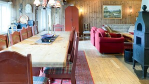 A dining area with a wooden table and chairs, a red sofa, and a blue cabinet.