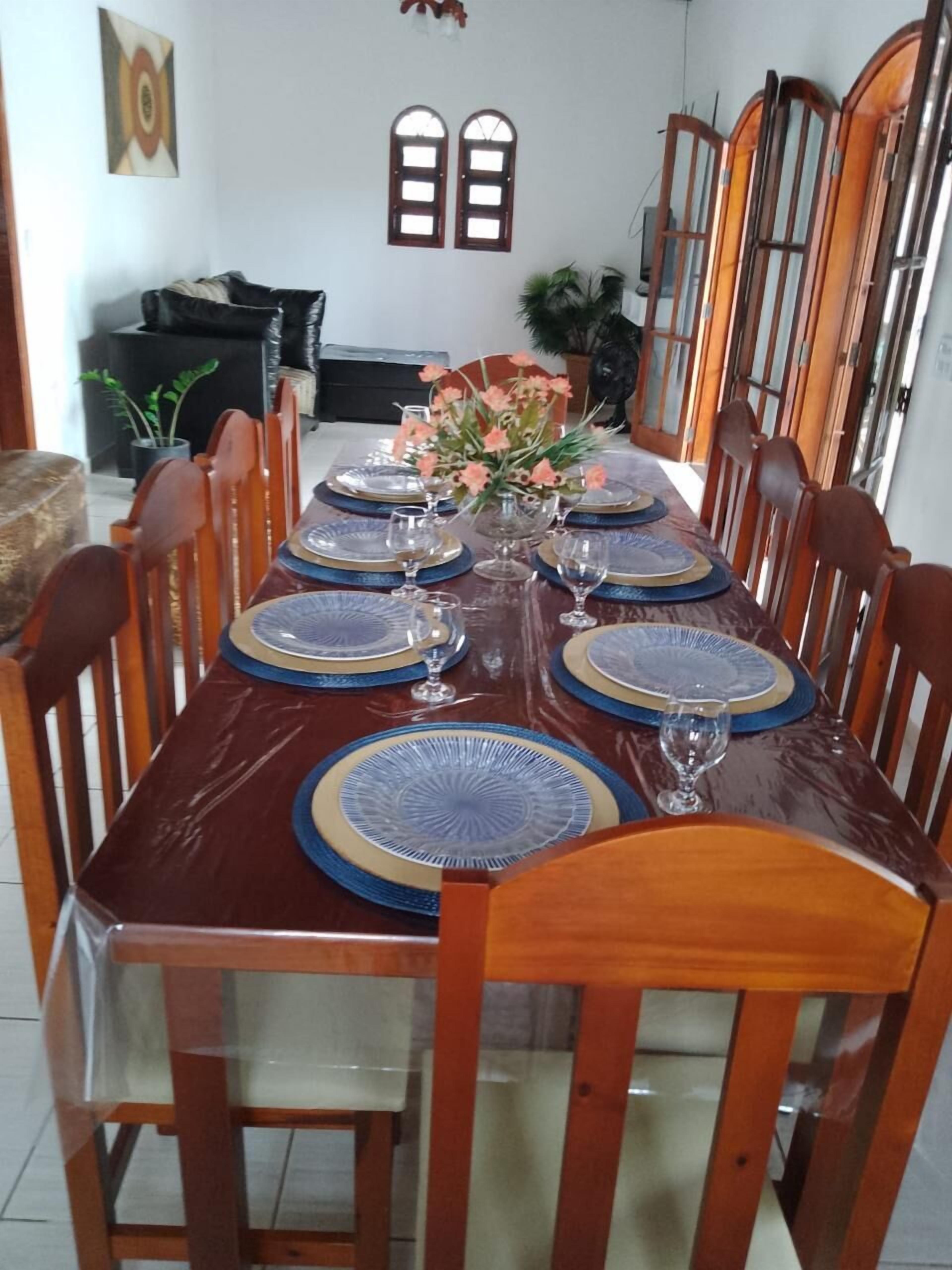 A dining table set with blue and gold plates, surrounded by wooden chairs.