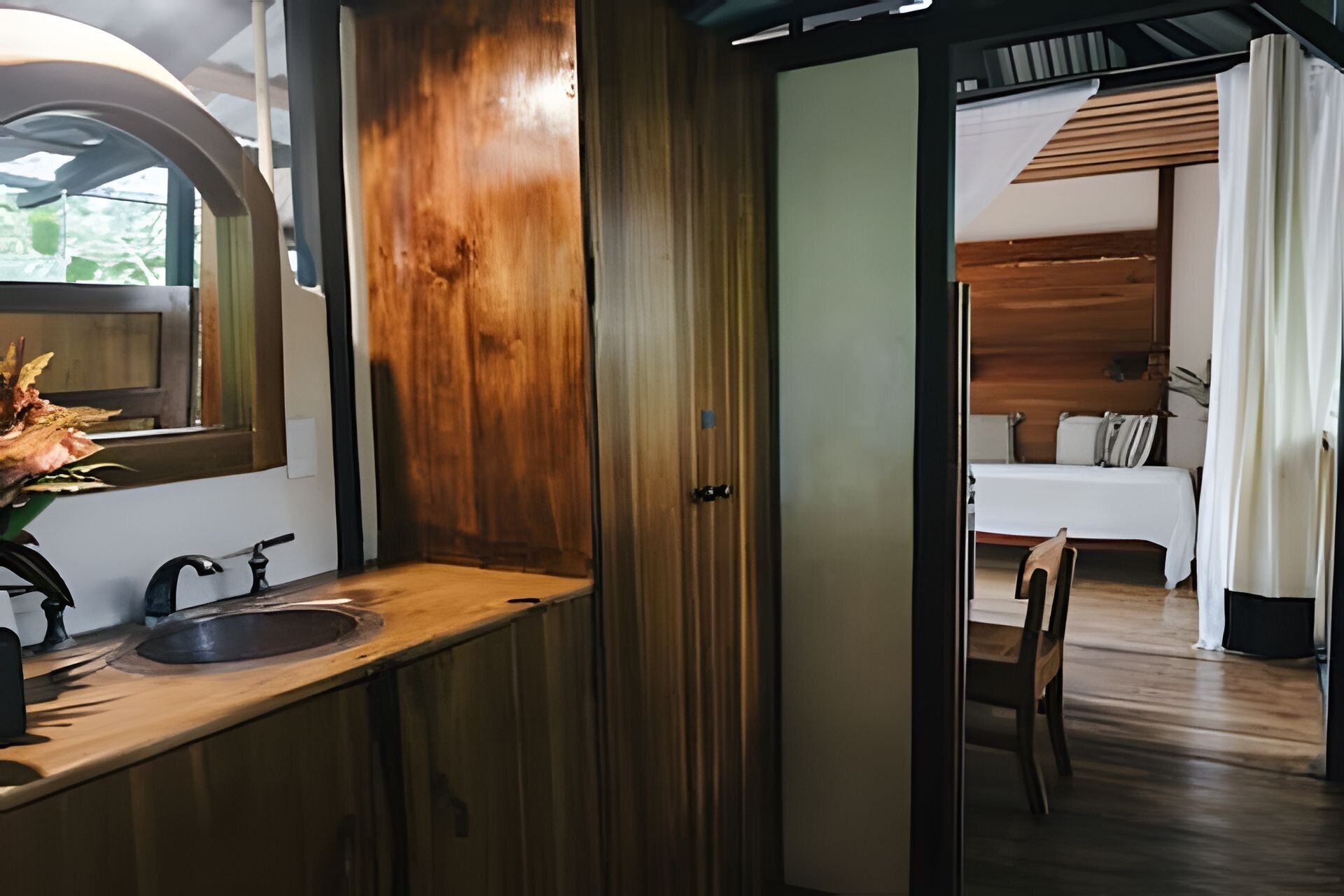 Een badkamer met een houten wastafel, een wasbak en een spiegel.