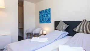 A hotel room with a bed, two chairs, a painting, and a lamp. - Lush Cabin in Camping Resort (Aabenraa)