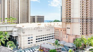 Een hoog hotel met meerdere verdiepingen, balkons en uitzicht op de oceaan.