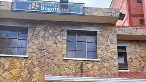 A stone building with a sign for Hotel Bogota Inn. - Hotel Casa Colonial  (Bogotá)