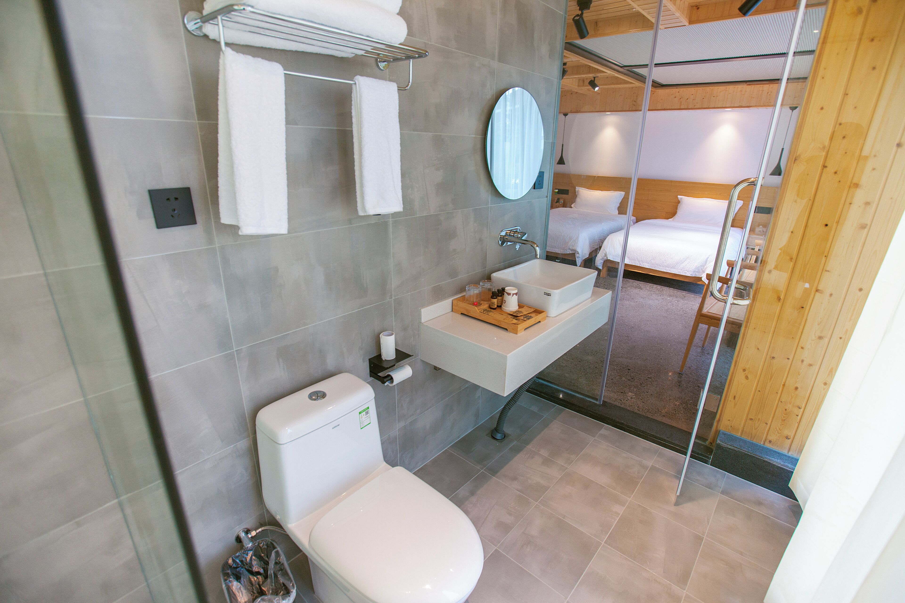 A modern bathroom with a toilet, sink, and glass shower enclosure.