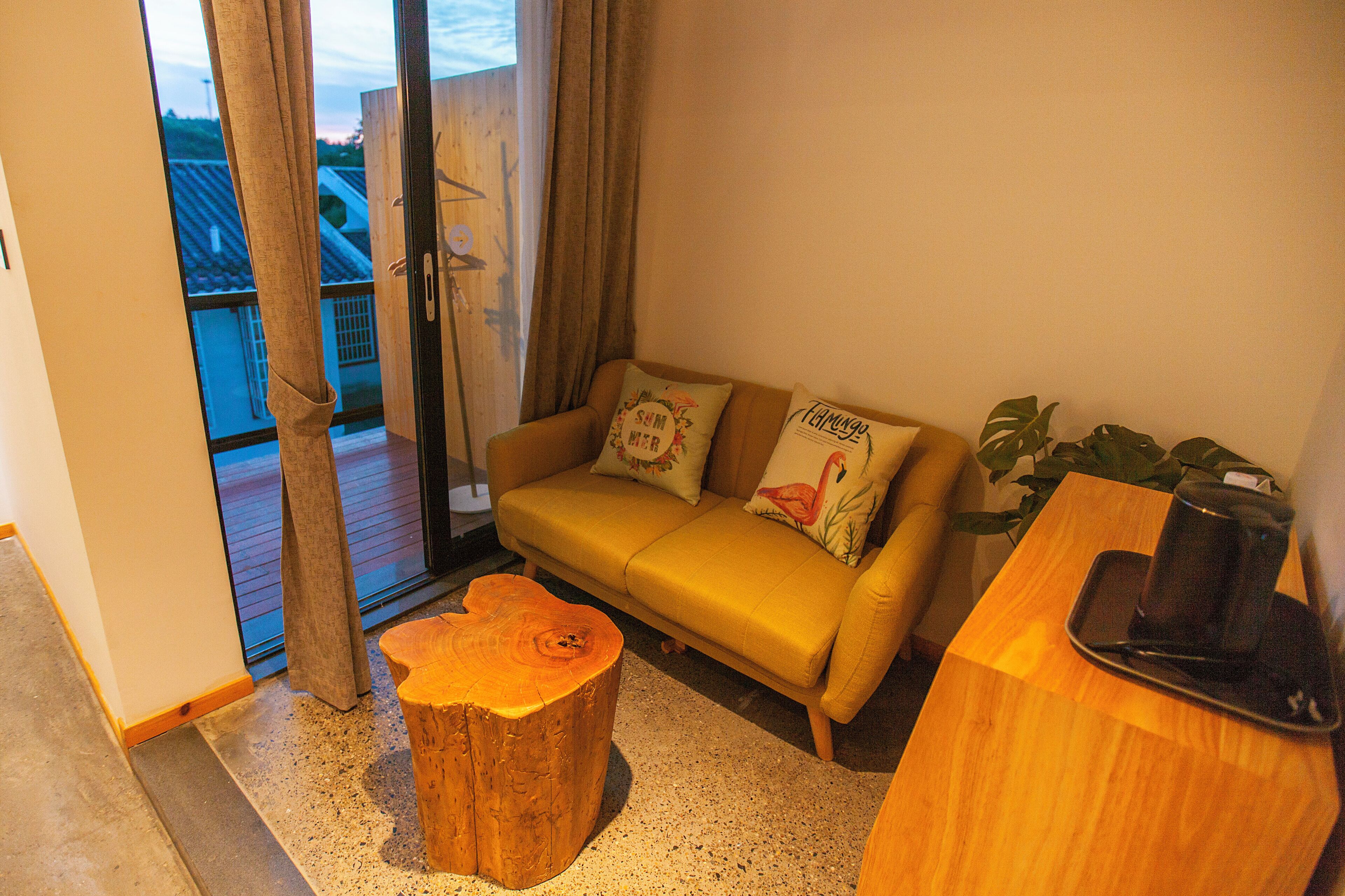 A cozy living room with a sofa, a wooden coffee table, and a plant.