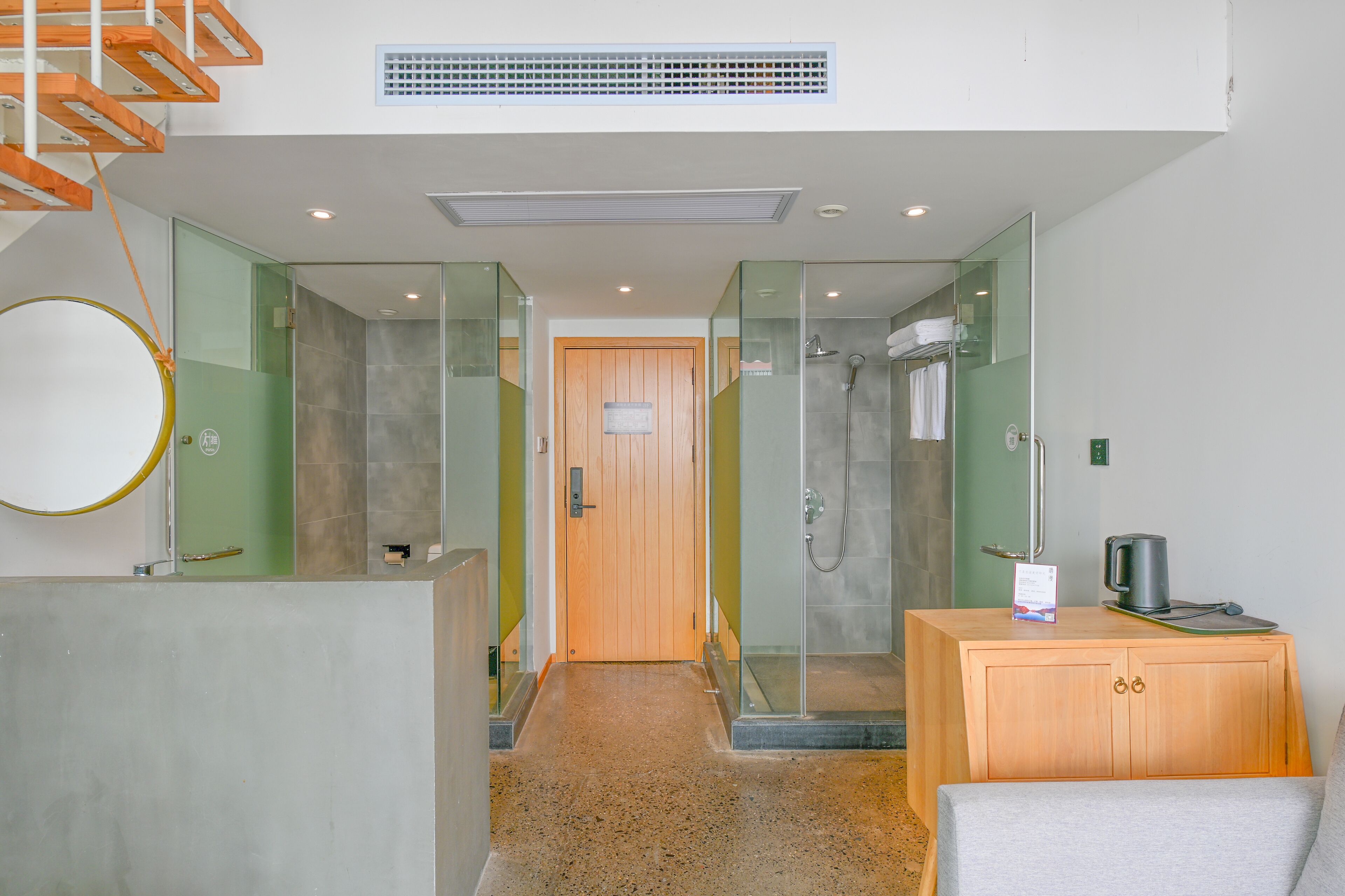 Un baño de hotel moderno con ducha, un armario de madera y un perchero.