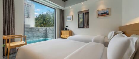 Une chambre d’hôtel moderne, dotée d’un grand lit, d’un petit bureau, d’une table de chevet et offrant une vue sur une piscine.