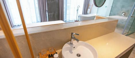 Ein modernes Badezimmer mit einem großen Waschbecken, einem Spiegel und einer Duschkabine.