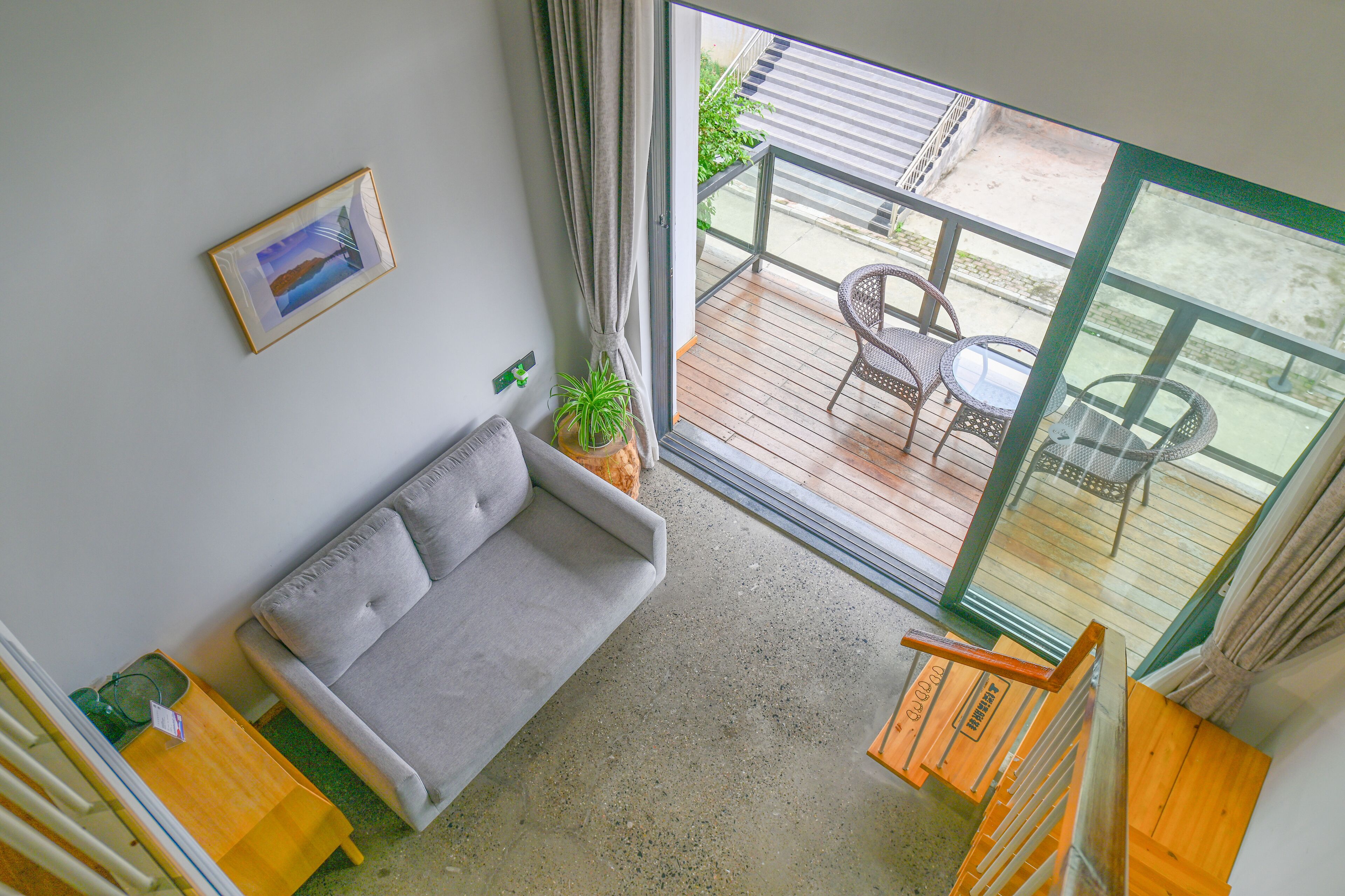 Un balcón con sofá, una mesa de comedor y sillas, y vistas al exterior.