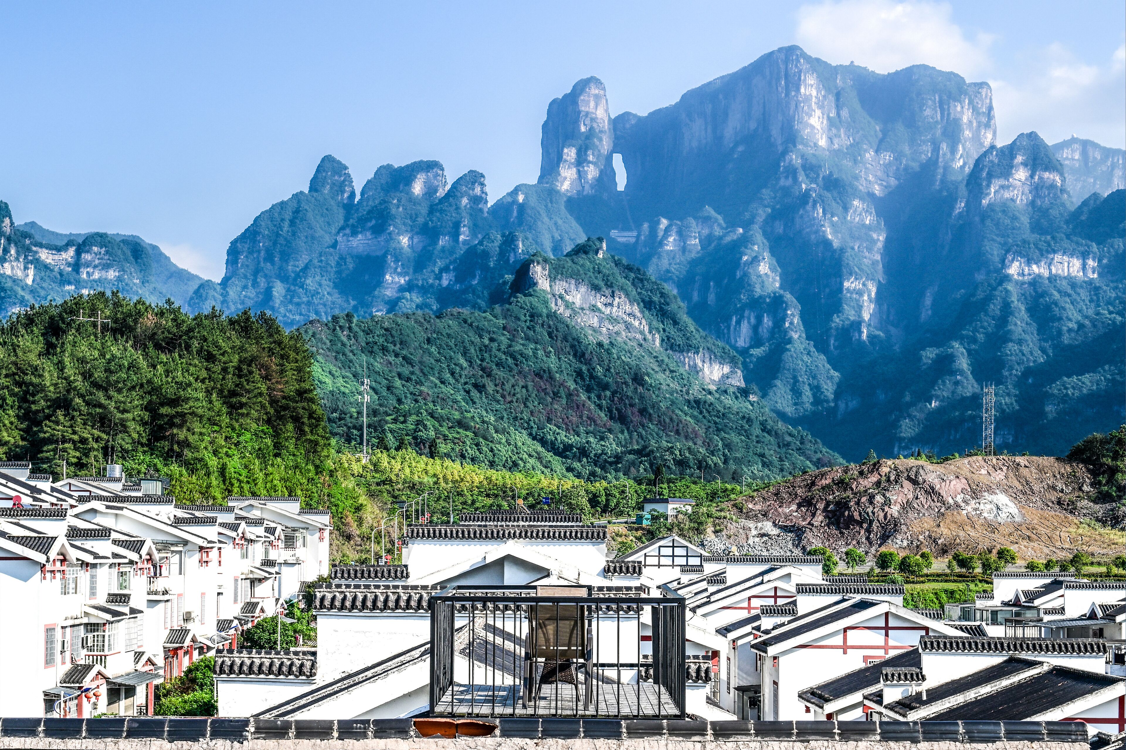 Un pueblo tradicional con edificios blancos y montañas escarpadas al fondo.