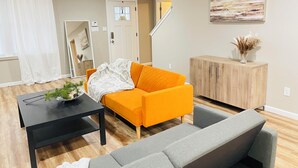 En moderne stue med sofa, sofabord og skab.