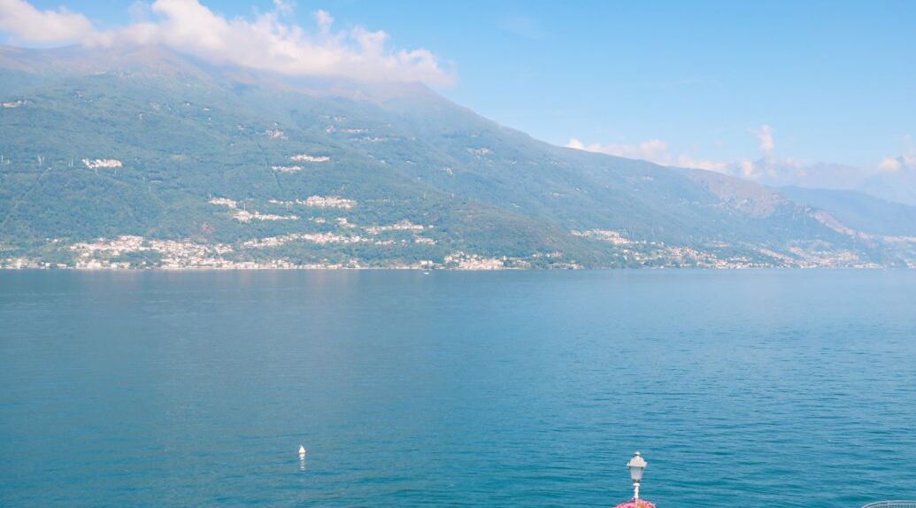 Ein ruhiger See mit einem Berg im Hintergrund und einer Boje im Wasser.