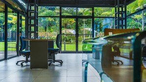 A modern office space with large windows, a desk, and office chairs. - Macaw House with private pool in Arenas Herradura (Playa Herradura)