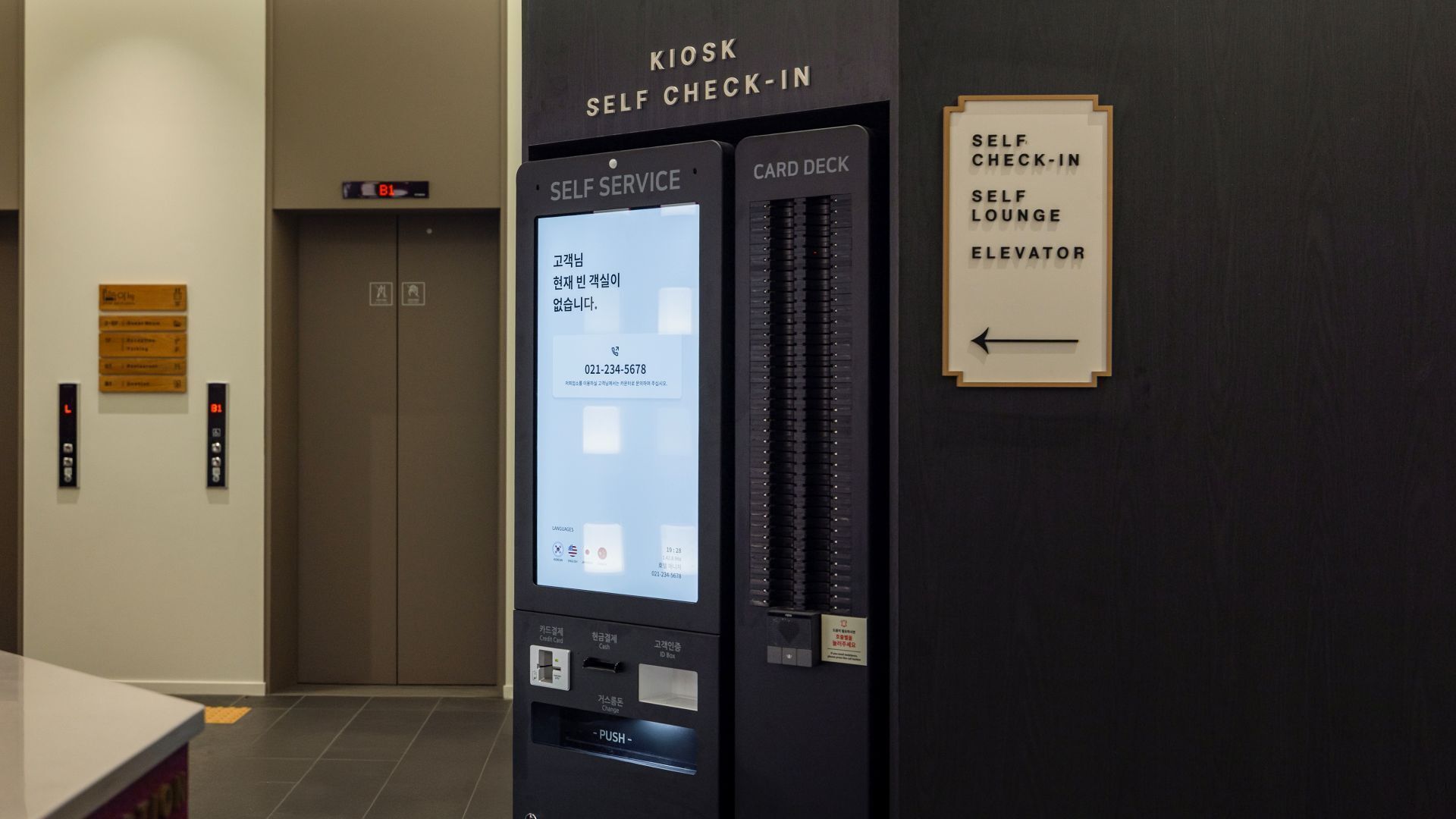 A self-service kiosk with a card deck and an elevator sign.