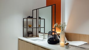 A modern bathroom with a large mirror, a white sink, a wooden vanity, and a vase with flowers. - Anook Hotel and Spa Seoul Seongsu Konkuk University (Seoul)