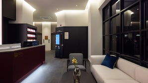 A hotel lobby with a reception desk, self-check-in kiosk, seating area, and a large window. - Anook Hotel and Spa Seoul Seongsu Konkuk University (Seoul)