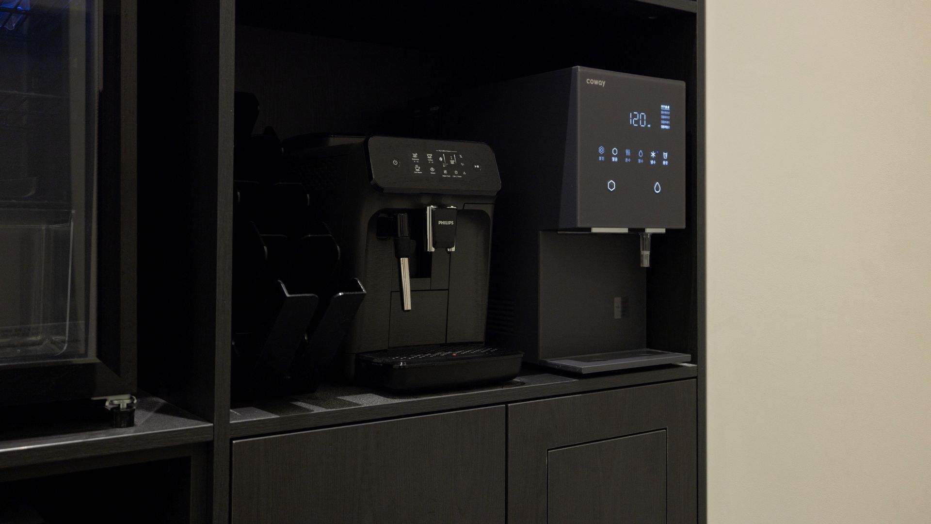 Una máquina de café y un dispensador de agua en una habitación oscura.