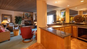 A spacious living area with a fireplace, comfortable seating, and a kitchen with granite countertops and modern appliances.