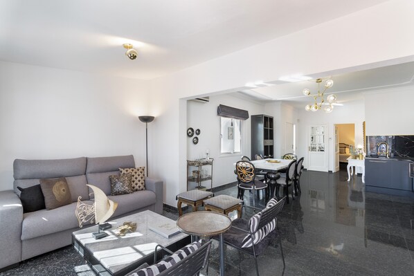 Un salon moderne avec un canapé, une table basse et un coin repas.