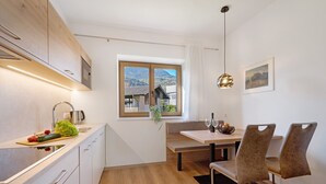 A modern kitchen with a wooden countertop, a built-in oven, and a window with a mountain view. - Apartment 'Fuchsberger  A' with Mountain View, Wi-Fi and Air Conditioning (Lana)